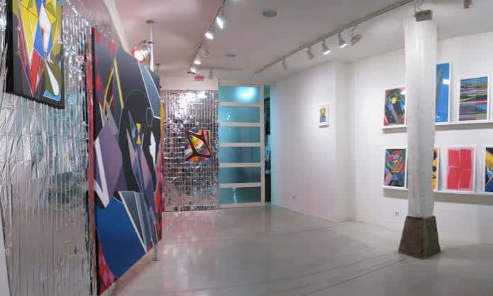 Vista del interior de la galería mostrando obras de arte y una columna central
