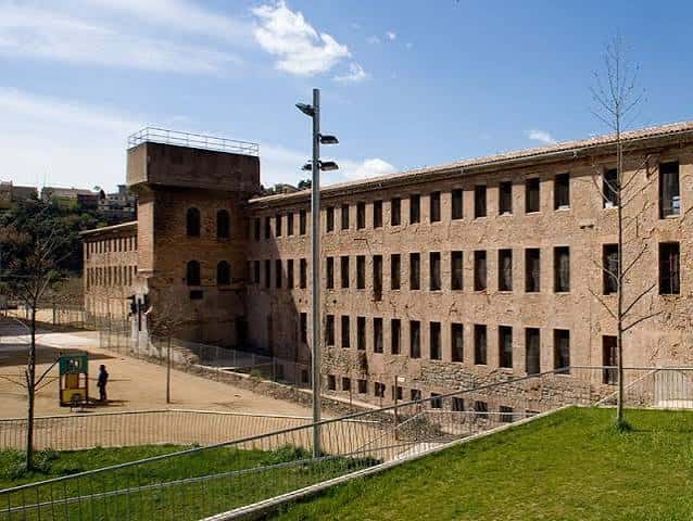 Vista exterior de la Fàbrica dels Panyos mostrando su fachada de ladrillo y torre característica