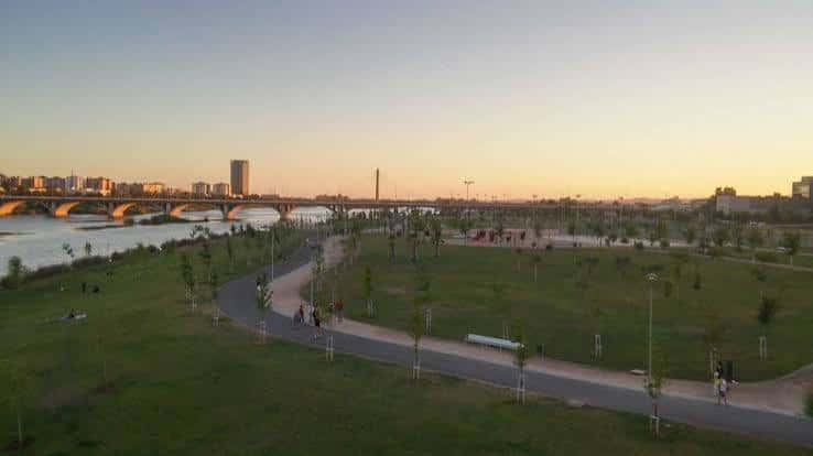 Vista panorámica del Parque del Guadiana al atardecer con senderos y puente al fondo