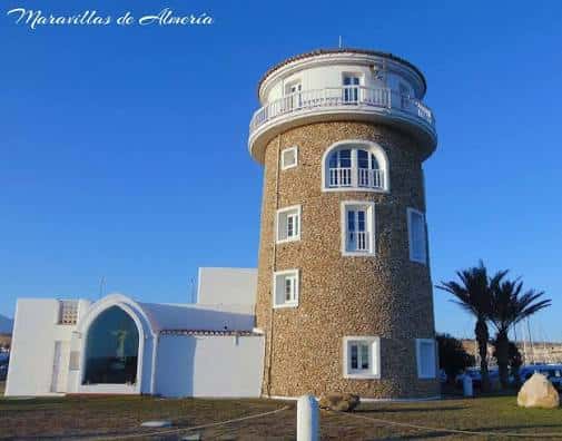 Torre del Puerto de Almerimar con fachada de piedra y balcón circular bajo cielo azul