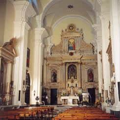 Interior del convento con altar principal y bancos de madera