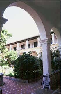 Patio interior del convento con arcos y vegetación, ideal para eventos al aire libre