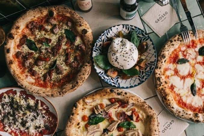 Mesa con variedad de Pizzas y Platos Italianos