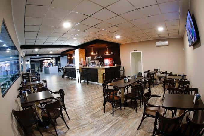 Sala de descanso y bar con mesas y sillas en IndoorLand