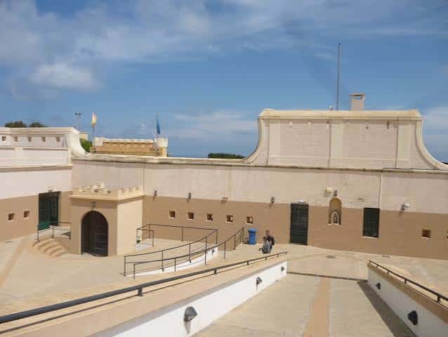 Plaza interior del fuerte con rampas de acceso y vistas al mar en el horizonte