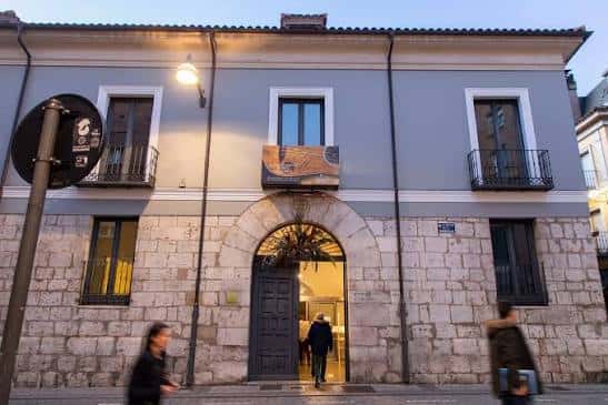 Entrada iluminada de Casa Revilla al atardecer, mostrando el ambiente acogedor del lugar