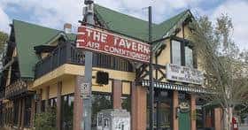 Fachada exterior del local The Tavern con letrero de aire acondicionado