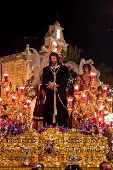 Paso de la Hermandad del Prendimiento iluminado por la noche con la imagen de Jesús y los ángeles