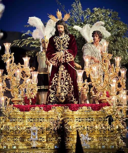Detalle del paso procesional con la imagen de Jesús en el huerto y los ángeles con velas encendidas