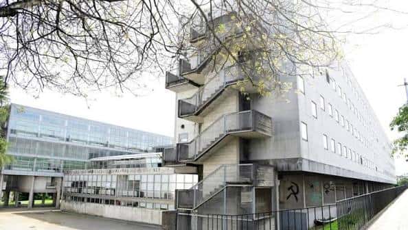 Fachada lateral de la Facultad de Filología con escaleras exteriores y árboles