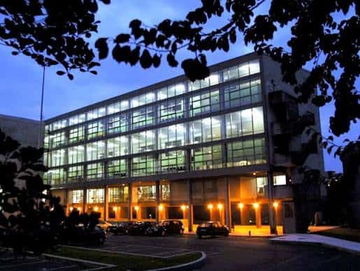 Edificio de la facultad iluminado por la noche con luces cálidas en la entrada