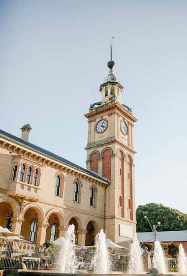 Detalle de la torre del reloj con fuentes en primer plano