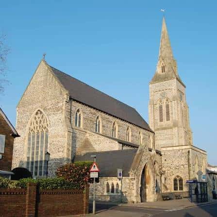 Vista exterior de la iglesia St Jude's en Portsmouth con su característica torre y aguja bajo un cielo despejado