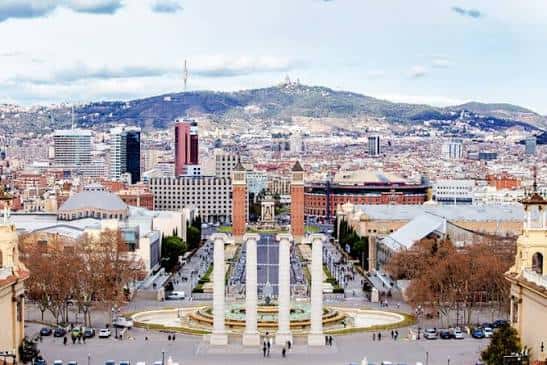Vista aérea del recinto ferial desde la Font Màgica, mostrando la Avenida de la Reina Maria Cristina y la montaña de Montjuïc al fondo