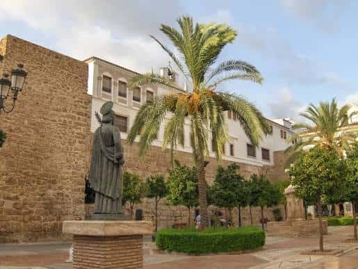 Plaza de la Iglesia en Marbella con estatua y palmeras bajo cielo parcialmente nublado