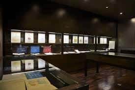 Sala de exposiciones con vitrinas iluminadas y documentos históricos