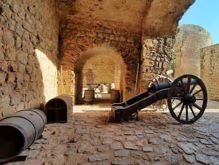 Interior de la fortaleza con cañones históricos y muros de piedra