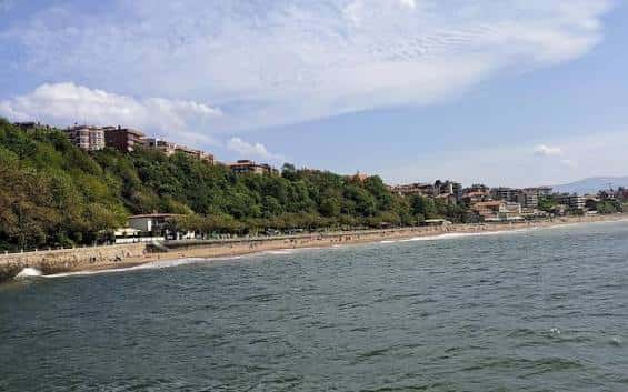 Playa de Ereaga desde el mar con edificios y vegetación en la costa