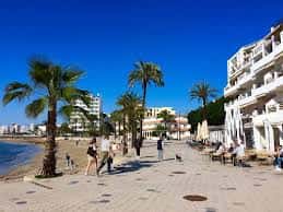 Vista panorámica de la Plaza Julià Verdera con palmeras y edificios blancos frente al mar