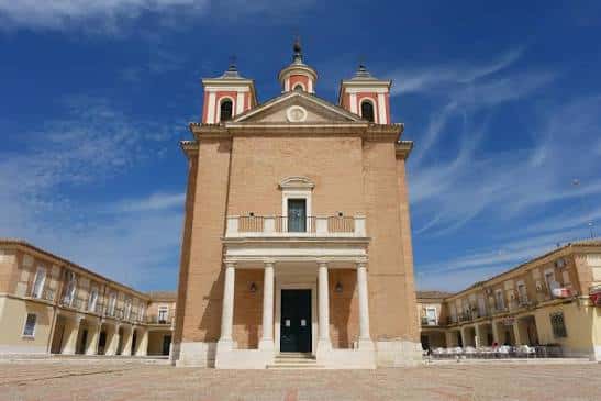 Vista frontal de la fachada principal del Real Cortijo de San Isidro con su iglesia y pórtico