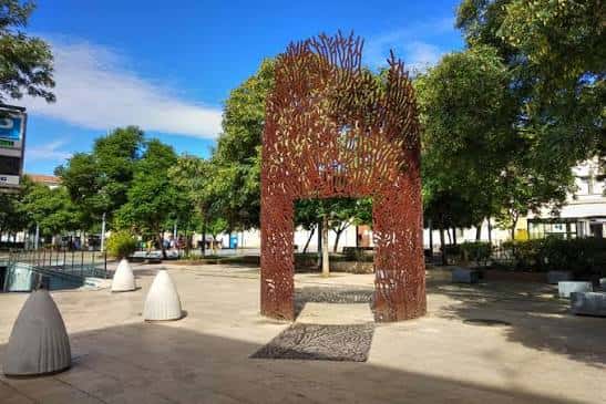 Escultura metálica de gran tamaño en el centro de la plaza