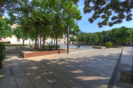 Vista general de la plaza con árboles y zonas de descanso