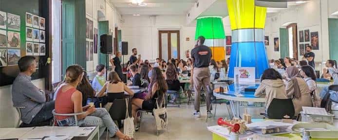 Evento cultural en el interior del espacio con público y decoración colorida