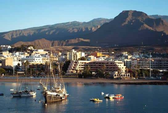 Vista panorámica del Puerto de Los Cristianos con embarcaciones y montañas al fondo