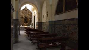Interior de la iglesia con bancos de madera y azulejos decorativos en las paredes