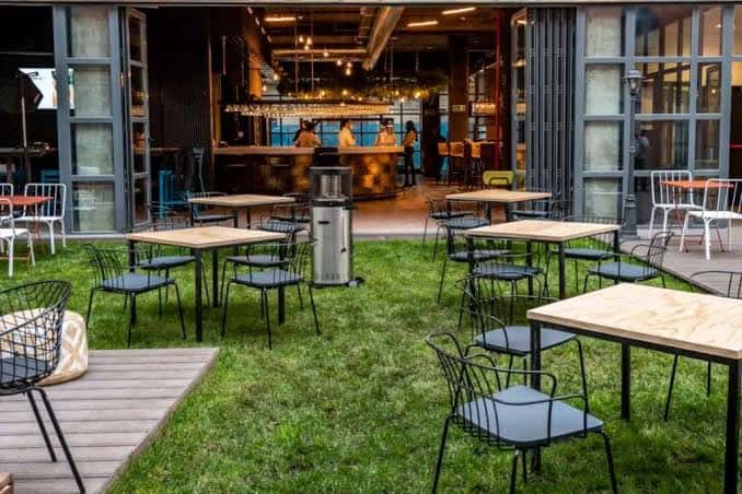 Terraza exterior con césped y mobiliario para eventos al aire libre