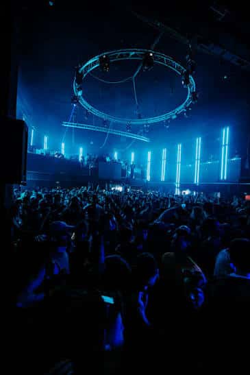 Interior del club con iluminación azul y anillo de luces sobre la pista de baile