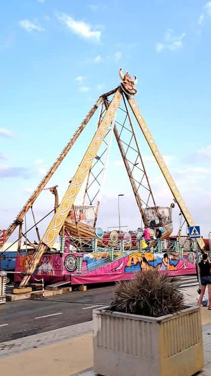 Atracción de feria en el recinto ferial de Gran Vía de Villaverde, con estructura de barco pirata y cielo despejado