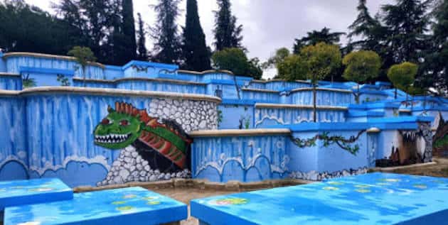 Detalle de las cataratas con murales artísticos y vegetación circundante