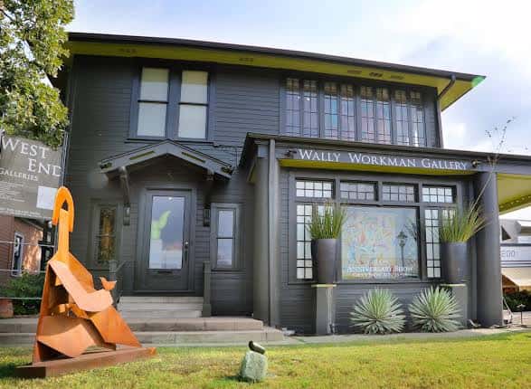 Fachada exterior de la galería con escultura de metal en el jardín