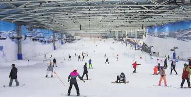Pista de esquí interior con personas practicando deportes de nieve