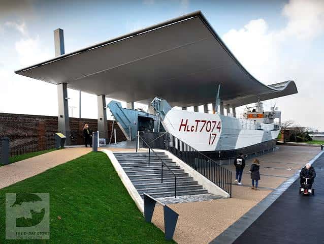 Vista exterior del barco LCT 7074 bajo su cubierta moderna con visitantes