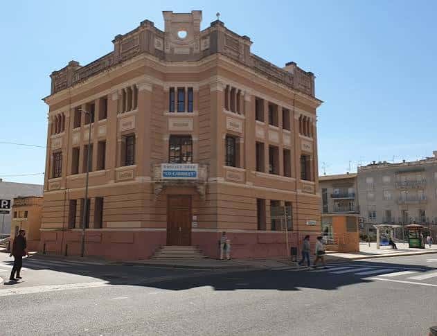 Fachada principal del edificio histórico Lo Carrilet con detalles arquitectónicos y personas caminando