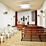 Interior de la ermita con bancos de madera y decoración sencilla
