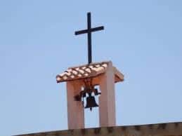 Detalle de la campana y cruz en la torre de la ermita
