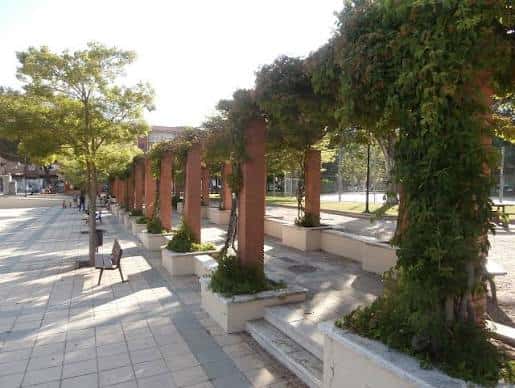 Paseo del parque con pérgola de ladrillo y enredaderas