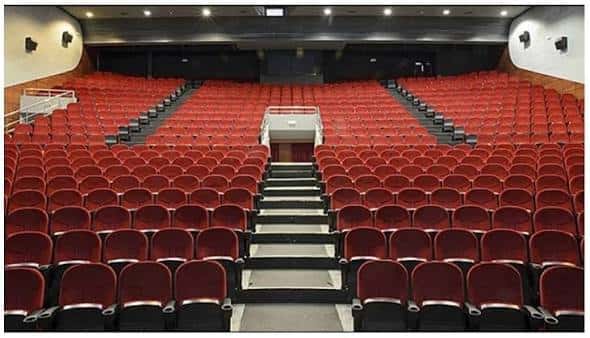 Vista desde el fondo del auditorio con butacas rojas y escaleras centrales