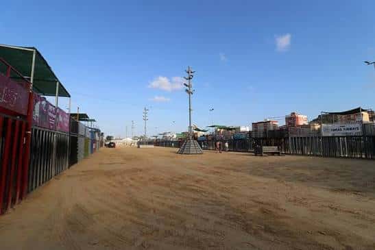 Vista del suelo de tierra del recinto ferial con casetas a los lados