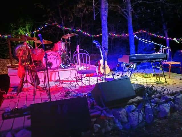 Escenario al aire libre de Sessions on Mary con instrumentos y luces de colores