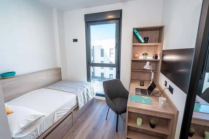 Habitación doble con dos camas, escritorio y balcón