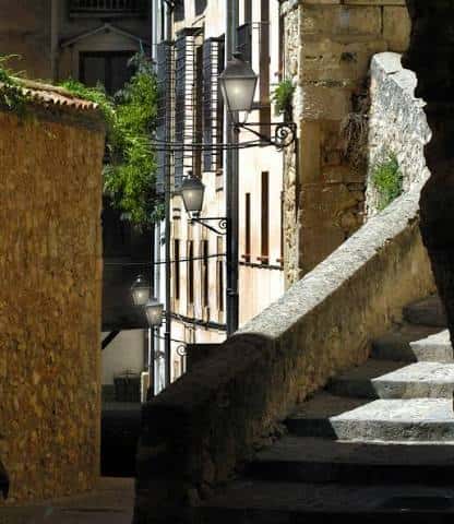 Escalinata de piedra con farolas antiguas y fachadas tradicionales de Cuenca
