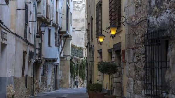 Callejón empedrado con iluminación cálida y arquitectura típica de la ciudad