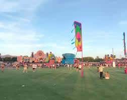 Vista panorámica del recinto ferial durante el día con atracciones y público en el campo
