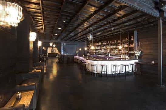 Interior del bar principal con iluminación cálida y mobiliario moderno