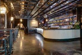 Espacio amplio del bar con techo industrial y ambiente acogedor para eventos