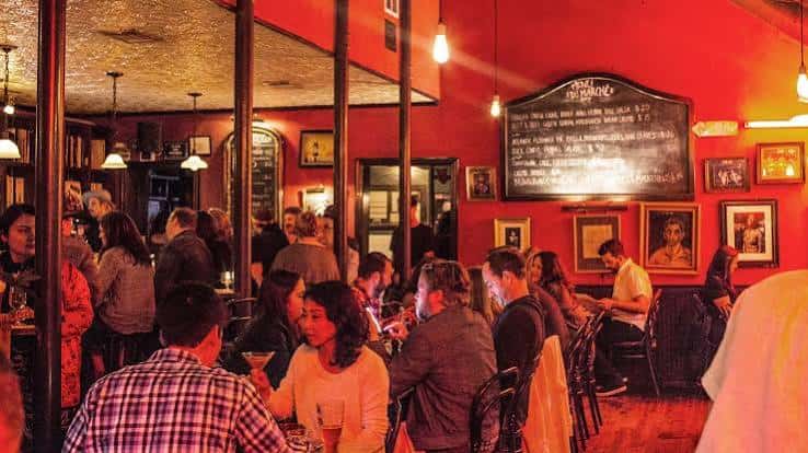 Vista del interior con clientes sentados y menú en la pared